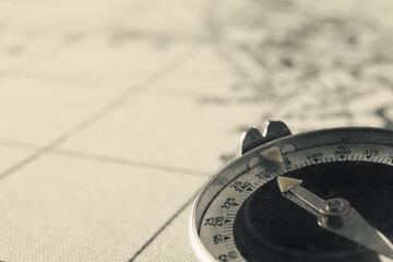 Magnetic old compass on world vintage  map.Travel, geography, navigation, tourism and exploration concept background.Macro shot, shallow focus.