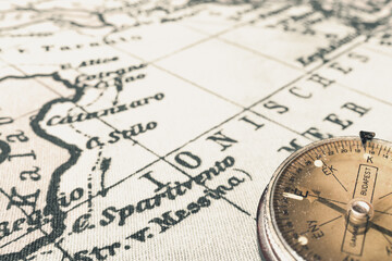 Magnetic old compass on world vintage  map.Travel, geography, navigation, tourism and exploration concept background.Macro shot, shallow focus.