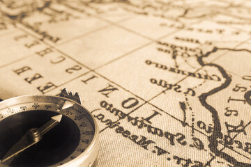 Magnetic old compass on world vintage  map.Travel, geography, navigation, tourism and exploration concept background.Macro shot, shallow focus.