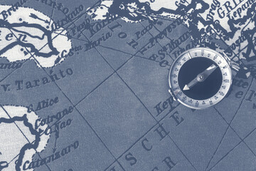 Magnetic old compass on world vintage  map.Travel, geography, navigation, tourism and exploration concept background.Macro shot, shallow focus.