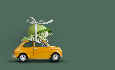 Retro car carrying an easter egg atop with lilies of the valley bunch. Happy Easter background - 498493219