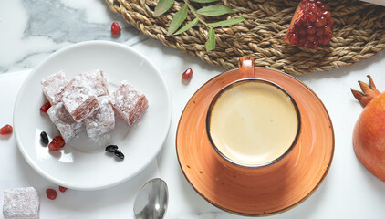cup of fresh coffee and a cube of soft Turkish delight, Turkish tea drinking, top view.
