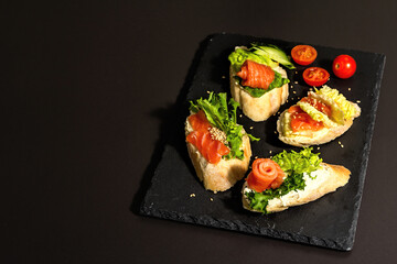 Assorted open sandwiches with salted salmon, cream cheese, salad leaves and cucumber. Seafood