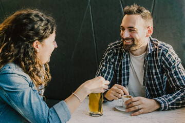 ngaged couple laughs and jokes in a bar - Friends have fun while having a drink in a coffee bar