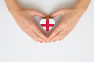 The national flag of England in female hands. The concept of patriotism, respect and solidarity...