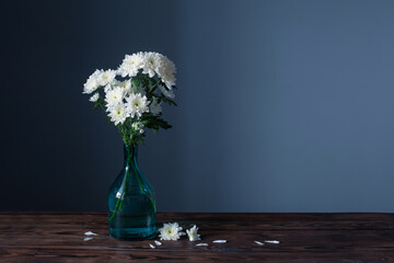 white  chrysanthemums in  glass vase on wooden background