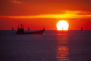 A fishing boat sailing across the Lagoons of Grado in the Upper Adriatic Sea at sunset