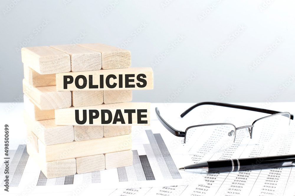 Poster policies update is written on wooden blocks on a chart background
