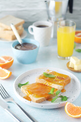 Sandwiches with marmalade, orange juice and coffee ready for breakfast	