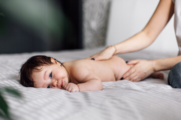 Closeup portrait of naked baby lying on tummy on bed, free copy space, selective focus. Cute little...