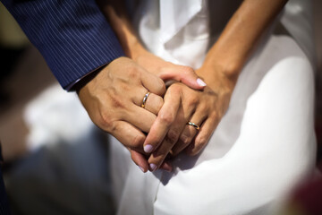 Wedding Love For for Life - Groom and Bride holding hands with Wedding Rings on close up