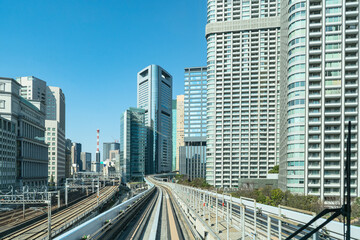 Fototapeta na wymiar Railways of Japan. Road infrastructure in Tokyo. Railway track near skyscrapers. Tokyo transport network. Railway between Tokyo and Odaiba. Overpass for high-speed trains. 