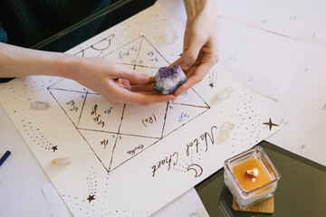 Woman holding crystals in her hands. Beautiful hand drawn natal chart.
