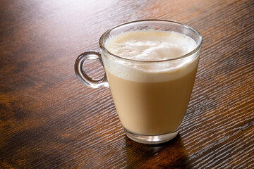 glass of cappuccino coffee on a wooden table