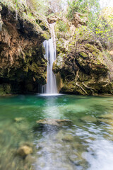Beautiful waterfall with silky water and green moss with transparent water lake in Puente Palo (Marbella)