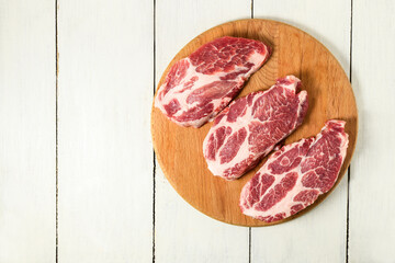 Sliced raw pork meat on wooden surface, top view
