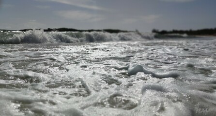 Wonderful beach on the blue ocean in the Dominican Republic. Close up image of water, macro. Cool tropical view. White clean sand, curly waves. Concept photo can be used as wallpaper, background