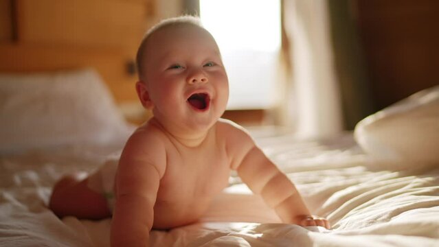 lovely asian baby playing at home in bedroom looking at camera smile, real original audio track, Beautiful Smiling Baby, gorgeous little baby lie on bed and smile at camera with soft focus background