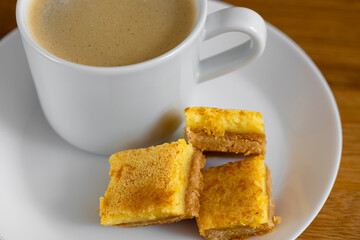 A cup of espresso coffee and orange cookies close-up stands on the table. Food photo.