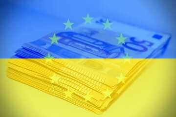 Euro banknotes with the Ukraine and European Flag as background, concept of financial help from...