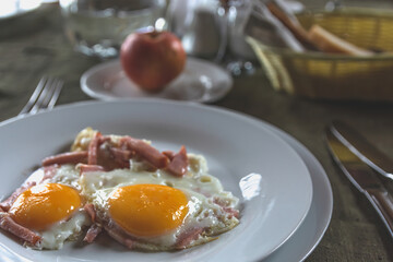 On the table is a plate with two fried eggs with bacon. Healthy breakfast that gives a lot of energy. Healthy lifestyle