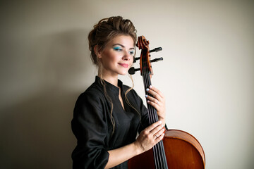 girl hugging the neck of the cello, portrait of a female cellist