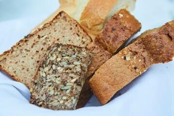 Bread of various types lies on a white napkin.