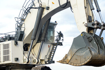 Big excavator in coal mine at cloudy day, low angle view