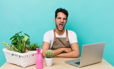 hispanic handsome man shouting aggressively, looking very angry. garden and plants concept