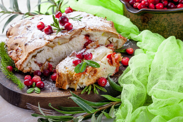 Delicious cranberry pie with fresh cranberries and herbs for Christmas on wooden plate - 498512414