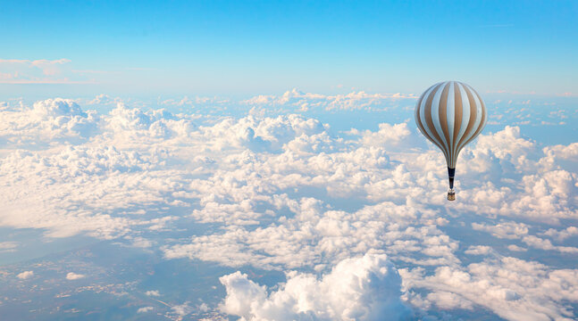 Classic type hot air balloon flying over the clouds