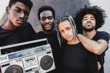 Group of young african people listening music from vintage boombox stereo outdoor - obrazy, fototapety, plakaty