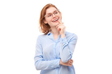 Smart redhead girl in glasses and business shirt holding chin thinks doubts, makes decision isolated on white studio background