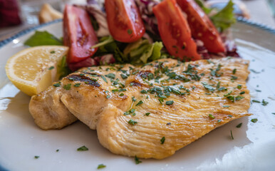 Typical Italian dish of chicken breast with tomato salad
