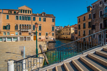 Fototapeta na wymiar VENICE, ITALY - August 27, 2021: View of stairs of a bridge over the beautiful canals of Venice.