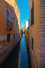 Fototapeta na wymiar View of an extremely narrow and empty canal in Venice, Italy