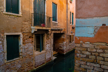 Fototapeta na wymiar Traditional house windows on Venice channels seen through the alleys