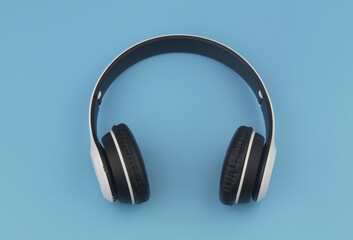 Fototapeta na wymiar Wireless headphones on blue background 