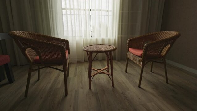 Two empty chairs and table near the window. Carefree old age, emptiness, loneliness, parting, separating concept. Gimbal shot, 4K