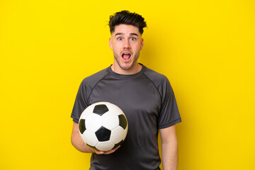 Handsome young football player man isolated on yellow background with surprise facial expression