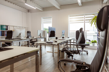 Interior of a modern light small company office. Workspace, office stationery and business environment comfort for interaction and development