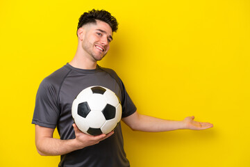 Handsome young football player man isolated on yellow background extending hands to the side for inviting to come