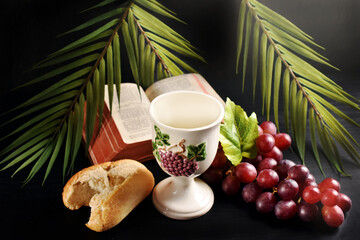 Eucharist symbol with bread  grape and chalice on black background