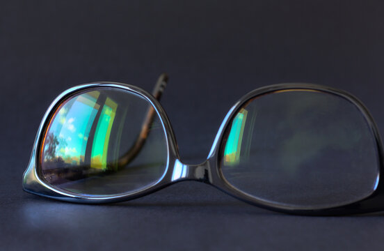 Anti-glare coating on the glasses. Glasses with black frames on a dark background.