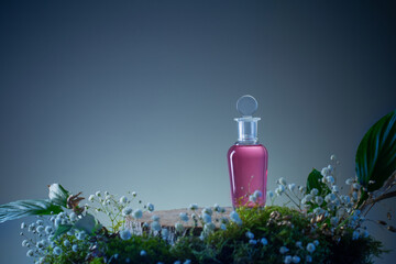 magic potion in glass bottle with plants and flowers on blue background