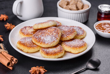 Cottage cheese pancakes with oats, syrniki on a black rustic background
