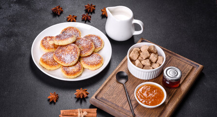 Cottage cheese pancakes with oats, syrniki on a black rustic background