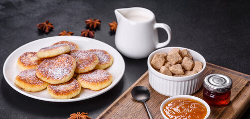 Cottage cheese pancakes with oats, syrniki on a black rustic background
