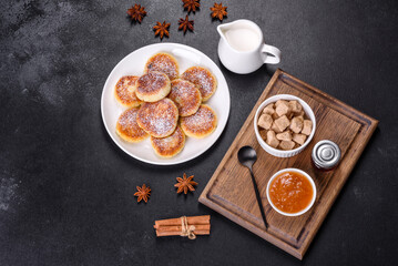 Cottage cheese pancakes with oats, syrniki on a black rustic background