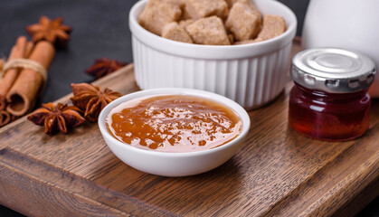Delicious apricot jam, milk and sugar on a wooden cutting board